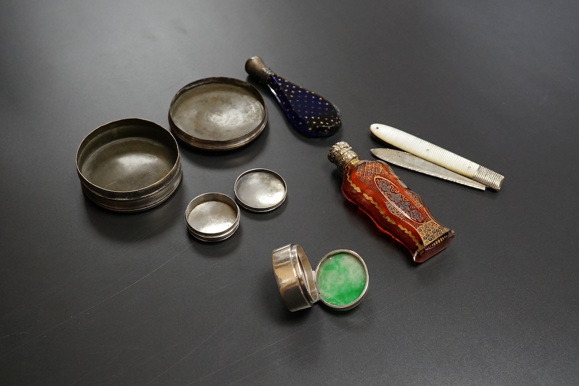 A collection of 19th century and later silver and white metal mounted items comprising three boxes, two glass scent bottles and a folding mother of pearl pen knife, largest 7.5cm high
